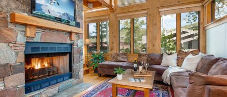 Living Room with plush leather furnishings, 40" TV, gas fireplace, and stunning floor to ceiling windows