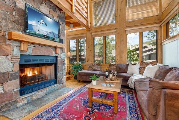 Living Room with plush leather furnishings, 40" TV, gas fireplace, and stunning floor to ceiling windows