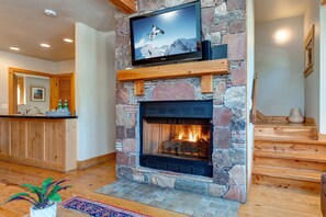 Living Room with plush leather furnishings, 40" TV, gas fireplace, and stunning floor to ceiling windows