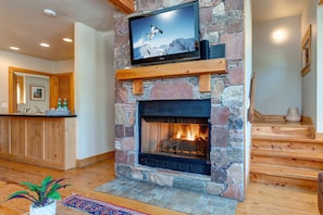 Living Room with plush leather furnishings, 40" TV, gas fireplace, and stunning floor to ceiling windows