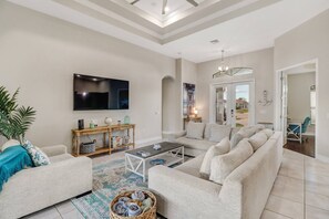 A large wallmounted flatscreen Smart TV with cable is located in the open great room.
