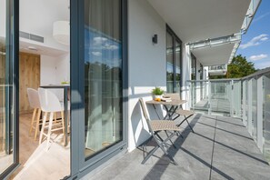 A spacious balcony with a table and chairs provides a comfortable place to spend time with loved ones.
