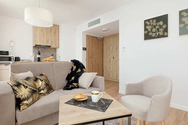 Cosy living room with soft sofa and coffee table. The whole creates a pleasant space to spend time with loved ones.