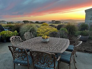 Summer sunset dining at backyard with views of fairway, beach and Bodega Head.