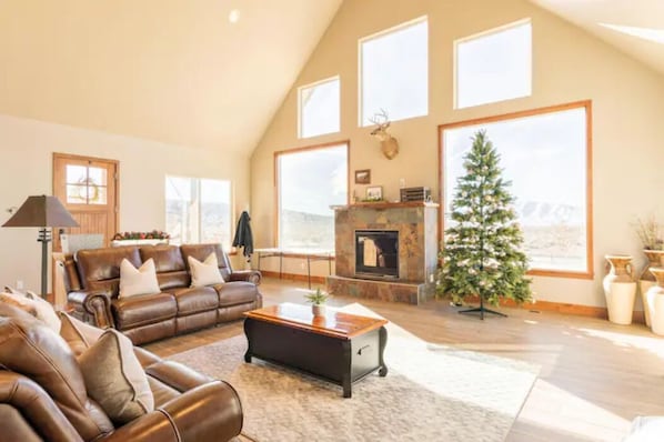 cozy living room with floor to ceiling windows and recline-able sofa set 