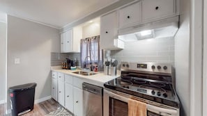 Kitchen fully equipped with appliances, cookware, tableware, cutlery and a stocked Keurig