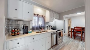 Kitchen fully equipped with appliances, cookware, tableware, cutlery and a stocked Keurig