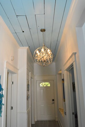 Entrance hallway with original shiplap ceilings and stunning chandelier.