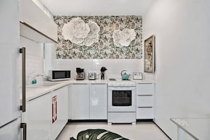 The kitchen is stocked with a full set of appliances including basic kitchen utensils.