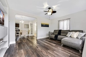 A spacious living room across the dining area. The living room has smart TV and a wifi located in the bookshelves. 