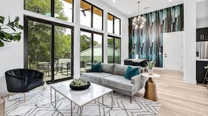 The luxurious living room has high ceilings and tons of natural light