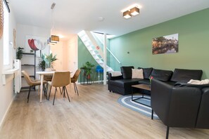 Stylish living room with a cozy seating area and dining table, perfect for shared meals and relaxation.