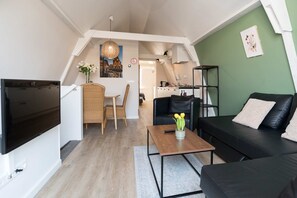 Cozy living area with a green accent wall and stylish decor, perfect for relaxing after a day in the city.