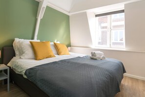 Spacious bedroom with a cozy double bed and plenty of natural light, ideal for a restful night.
