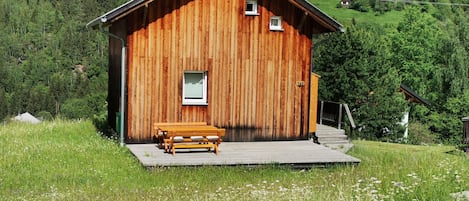 Blick auf das Chalet mit Blumenwiese und reichlich Platz zum spielen...