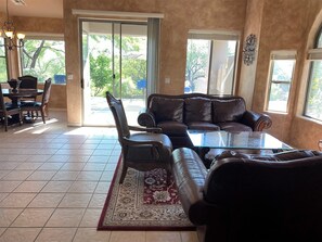 Looking in from front door into living room, door to back patio and dining room