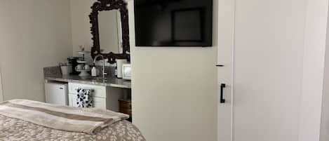 Queen bedroom suite, smart TV, kitchenette, bathroom behind barn door.