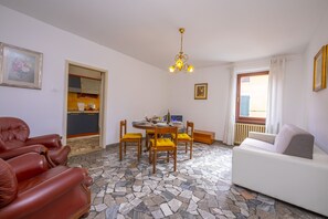 The living room with sofa, dining table and view of the kitchen