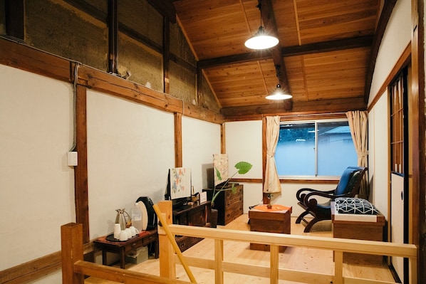 Living room for guests on the 2nd floor where beams lie on high ceilings and plaster walls and earthen walls settle down