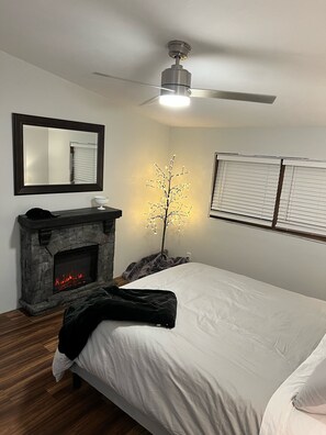Master bedroom with electric fireplace and views of the lake.
