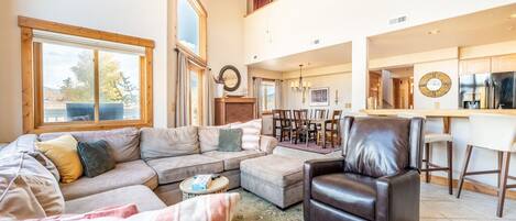 Spacious living area with vaulted ceilings, gas fireplace, flat screen TV and awesome views and great light thanks to the huge windows.