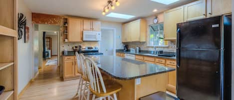 Spacious, sunny kitchen with skylights and granite bar.