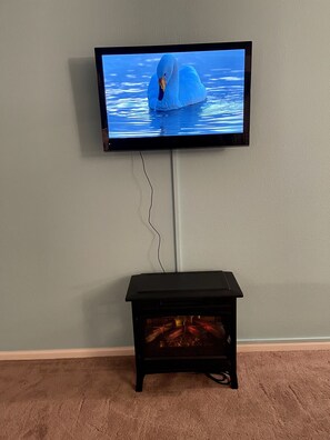 TV with Roko (guest Netflix) viewed from seating area, dining table & bed. 