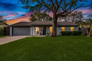 Big Live Oaks grace the front yard and are adorned with lovely downlights.