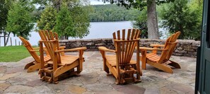 Stone patio with Adirondack chairs.  