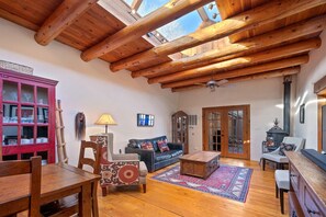 View of living room from kitchen showcasing old fashioned wood stove