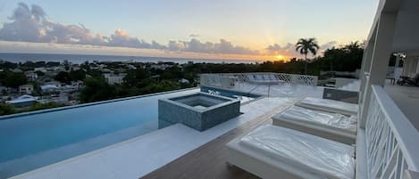 Outdoor sunbathing area, infinity edge pool & hot tub overlooking the sea