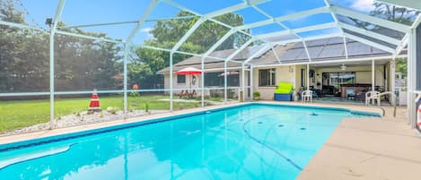 Large solar panel heated pool, 8' at deep end with sitting bench and steps.