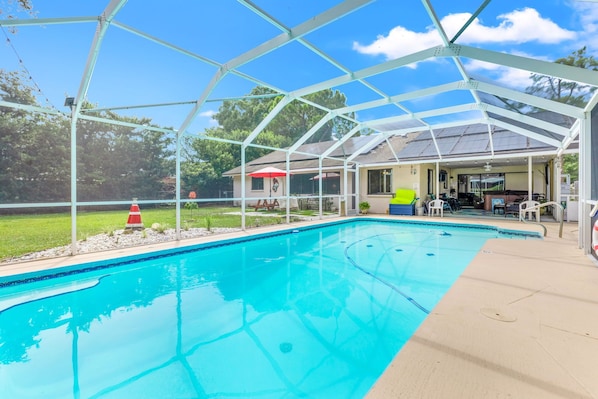 Large solar panel heated pool, 8' at deep end with sitting bench and steps.