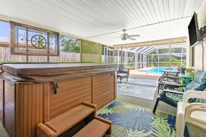 Spa / hot tub in screened in patio. Outdoor shower around the corner.