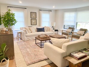 Open concept living room with bay window, opposite the kitchen