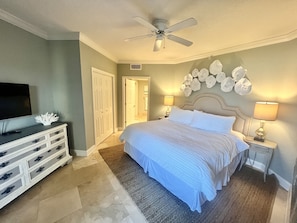 Master bedroom w/King size bed, balcony access, TV, and en-suite bath
