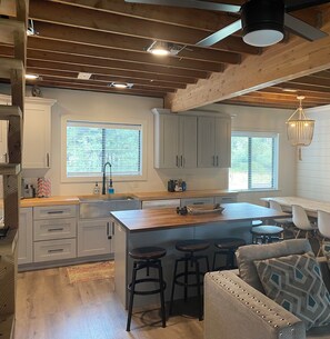 Warm inviting atmosphere w/wooden beams, white cabinets, butcher block counters