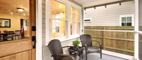 Screened front porch with view of historic Oak. 