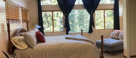 The master bedroom features a king-size bed and gorgeous forest views.