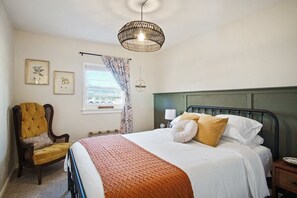Front Bedroom- QUEEN Bed, Vintage Chair, Luggage Rack.