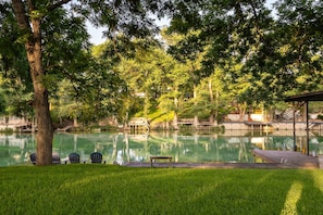 Enjoy a spacious waterfront lawn with water access. Shaded by trees.