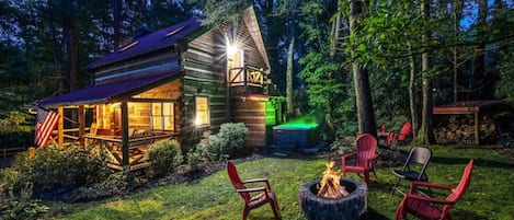 Cabin at dusk with fire blazing and Jacuzzi lite up! 