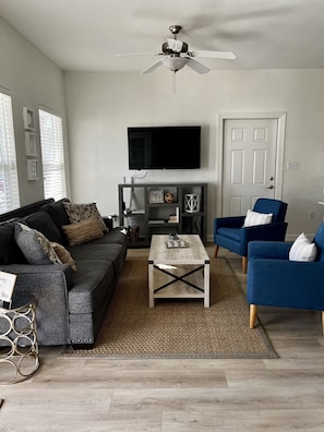 Living room with smart TV, new sofa and chairs