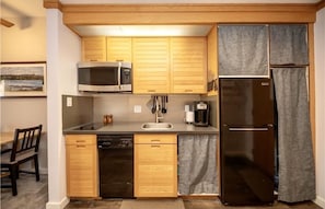 Kitchen has 2 burners, dishwasher, refrigerator, freezer, microwave, coffee