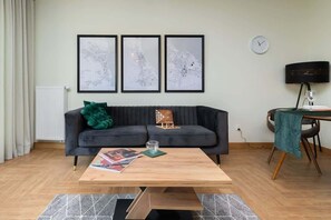A bright, modern living room with a comfortable sofa above which hangs paintings that complement the entire interior.