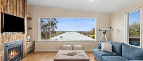 Huge windows perfectly frame the iconic landmarks of bluff, bridge, river and sea...