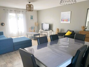 Salle à manger séjour lumineux, fenêtres traversantes.