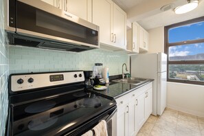 Fully equipped kitchen with microwave, stove, refrigerator and more appliances