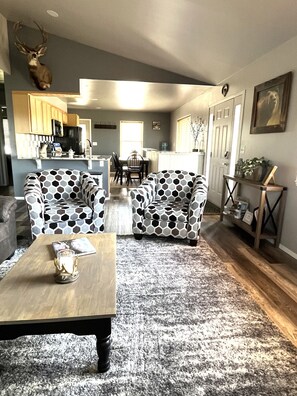 Open floor plan, living room to kitchen. Dining table and counter seating.