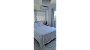 Room with double bed, air condition and ceiling fan.